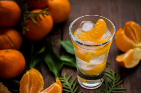 Glass with fresh juicy ripe Mandarins Tangerines, ice. Copy space and Closeup on dark background. Top view. Horisontalの写真素材