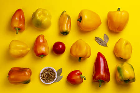 Mini sweet colorful peppers over yellow background