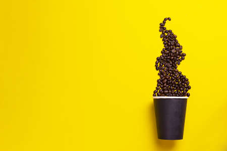 Coffee beans with thermo cup on a yellow backgroundの写真素材