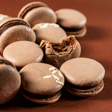 Some sweet tasty brown macarons dessert against a monochromatic brown background.の写真素材