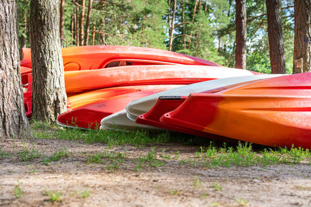 Plastic kayaks are stacked in the woods after an extreme descent down the river. Outdoor recreation, healthy lifestyle, outdoor entertainmentの写真素材