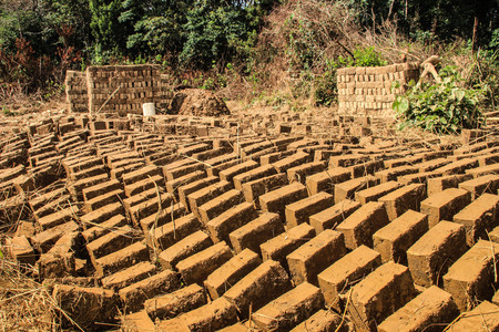 Homemade clay brick making in Uganda. The bricks are dried in the sun outside