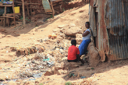 Kibera, Nairobi, Kenya - February 13, 2015: two African women near the huts are talking among the garbageのeditorial素材