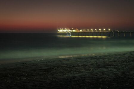 Pier on the Atlantic Ocean in Swakompund, Namibia. Beautiful sunset with a bright sky and soft...