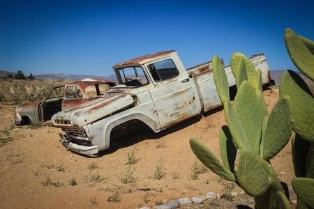 Abandoned old rusty cars in the desert of Namibia surrounded by cactus near the Namib-Naukluft National Park. Africaのeditorial素材