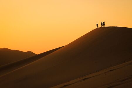 Sossusvlei, Namibia - April 28, 2015: The highest sand dunes in the world at sunset in the Namib Desert, in the Namib-Nacluft National Park in Namibia. People on the top of the duneのeditorial素材
