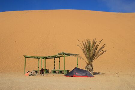 Sossusvlei, Namibia - April 28, 2015: The highest sand dunes in the world at sunset in the Namib Desert, in the Namib-Nacluft National Park in Namibia. Camping with a tent at the duneのeditorial素材