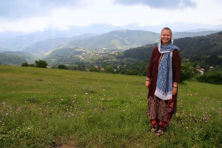 Stunning alpine views with vibrant grass and hills in the eastern Azerbaijani province of Iran. The lush nature of Iran in the north of the country. Girl tourist in a scarf.の写真素材