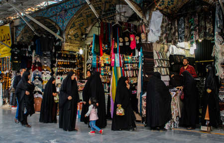 Kum, Iran - May 10, 2017: Famous Iranian market (bazaar) and women in black chodor choose goodsのeditorial素材
