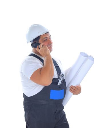 Confident worker with plans talking on mobile phone の写真素材