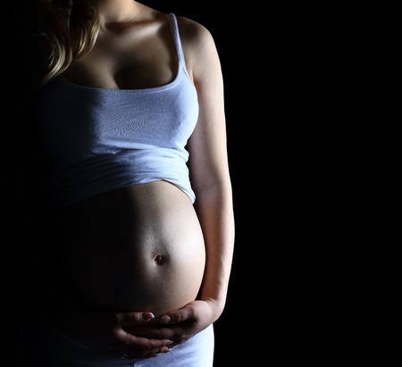 Beautiful pregnant woman on black backgroundの写真素材