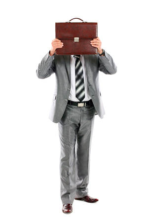 Young businessman who is afraid of anything and covering his face of the business briefcase isolated on white の写真素材