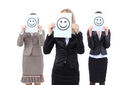 A beautiful young business women hiding behind a smiley face の写真素材