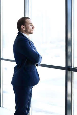 Composite image of thoughtful young businessman looking away