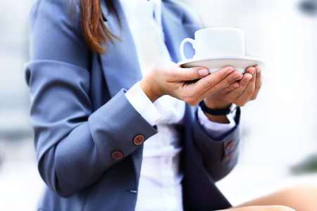 Hot drink in cup in hands close upの写真素材