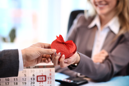 Happy woman hold Love symbol red heart. In office.の写真素材