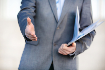 Businessman offering his hand for handshake. Greeting or congratulating gesture.の写真素材