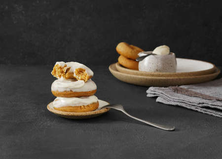 carrot donuts stacked with and a half of one on a dark background. copy space