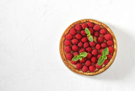 Tart with raspberries. cheesecake close up, decorated with raspberries and mint. top view. summer cake. copy spaceの写真素材