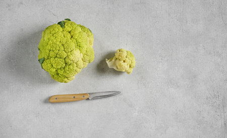 green Cauliflower on the concrete background with knife top view copy spaceの写真素材