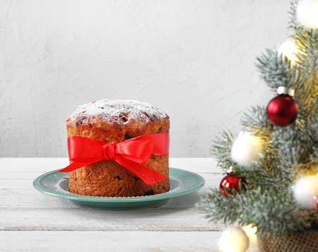 Homemade Panettone on light background with christmas tree. Traditional Italian Christmas Cake. copy spaceの写真素材