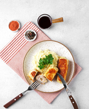 chicken cutlet with garnish of mashed potatoes on white background, top view