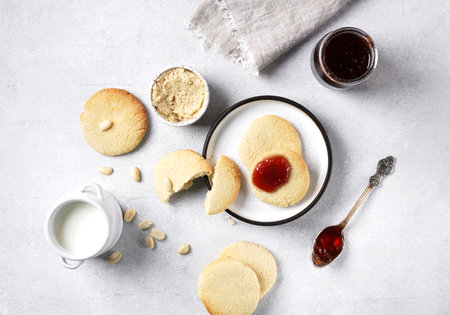 peanut butter cookies served with jam and bottle of milk on concrete backgroundの写真素材