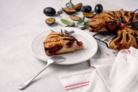 A Piece of tasty plums pie on white background, copy space
