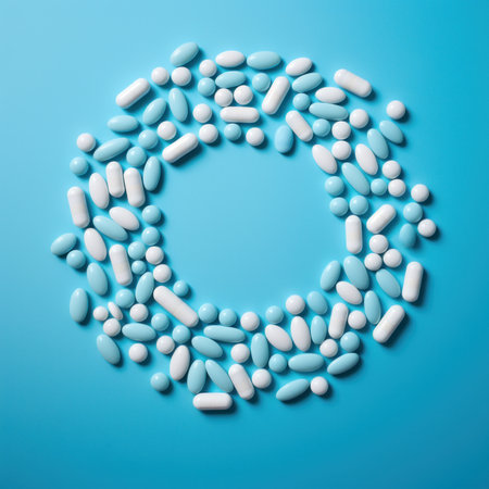 Different white and blue pills on blue background in the circle foarm, flat lay, copy spaceの素材