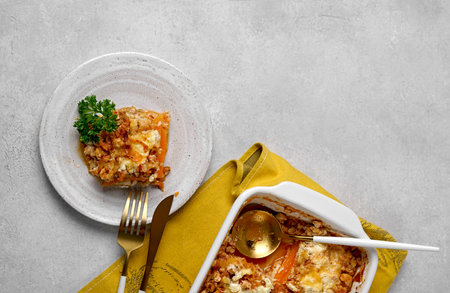 Italian food pumpkin lasagna with pumpkin instead of pasta leaves on plate and in the cooking dish.の写真素材