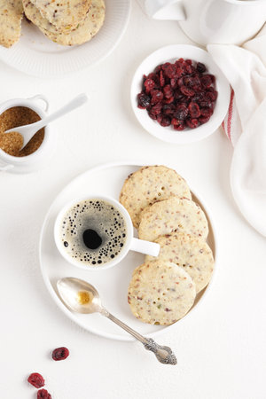 Cranberry shortbread cookies with coffee on the light table, morning breakfast, top viewの写真素材