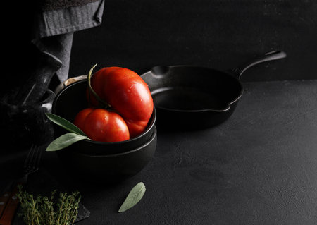 Big red tomato in black bowl. top view, copy spaceの写真素材
