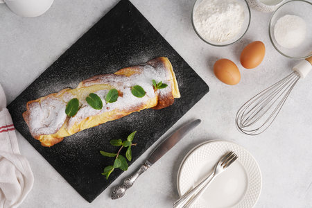 Serving option for Finnish pancake in roll with cream on black board In Top View