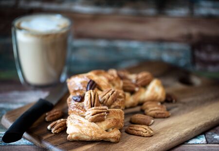 Pecan danish pastry on napkin and blur wooden board