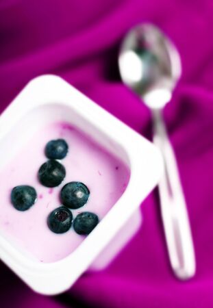 Yogurt with fresh blueberry on purple backgroundの写真素材