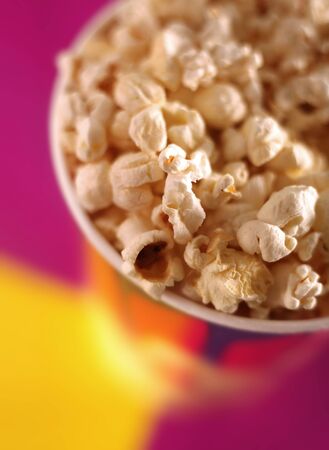 Popcorn in paper glass on violet backgroundの写真素材