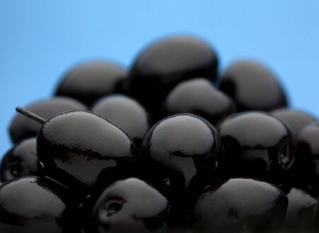 Black olive vegetable closeup on blue backgroundの写真素材