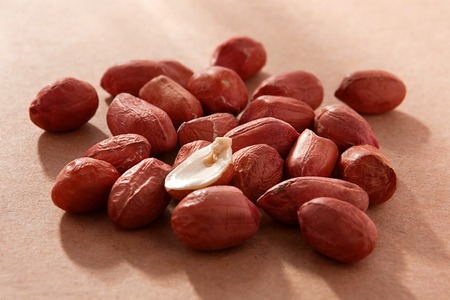 Peanut nut fruit group with shadow on brown background