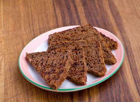Fried black bread slice on plate