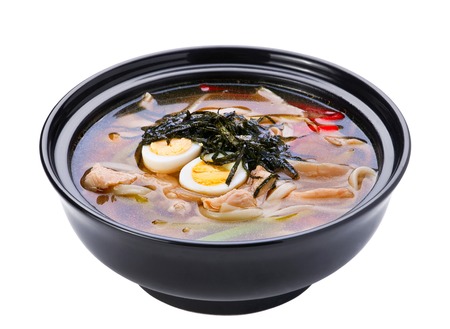 Soup with chicken meat and noodles in black plateの写真素材