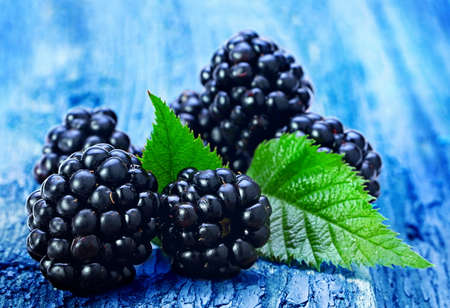 Blackberry fruit with leaf on old wood background