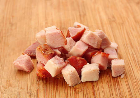 Pork meat smoked slice cube closeup on wood tableの写真素材