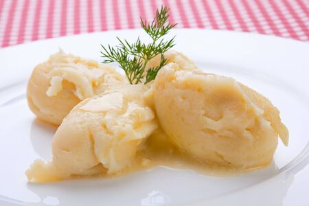 Mashed potatoes portion with dill on white plateの写真素材