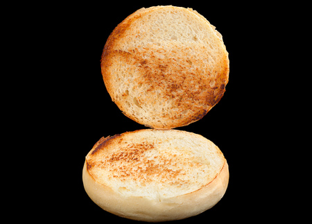 Homemade hamburger bun with fried surface on black backgroundの写真素材