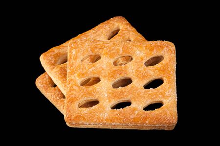 Square perforated cookie isolated on black backgroundの写真素材