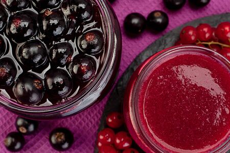 Closeup black and red currant jam in glassの写真素材