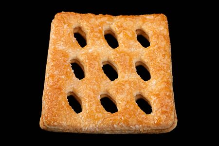 Square perforated cookie isolated on black backgroundの写真素材