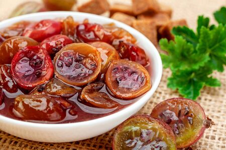 Red Gooseberry jam with berry closeup viewの写真素材