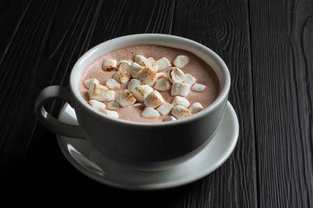 Coffee latte with marshmallow on black table