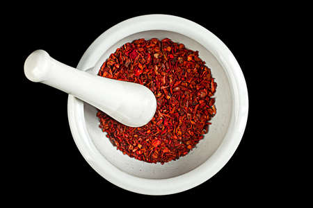 Ceramic pounder with red pepper isolated on blackの写真素材